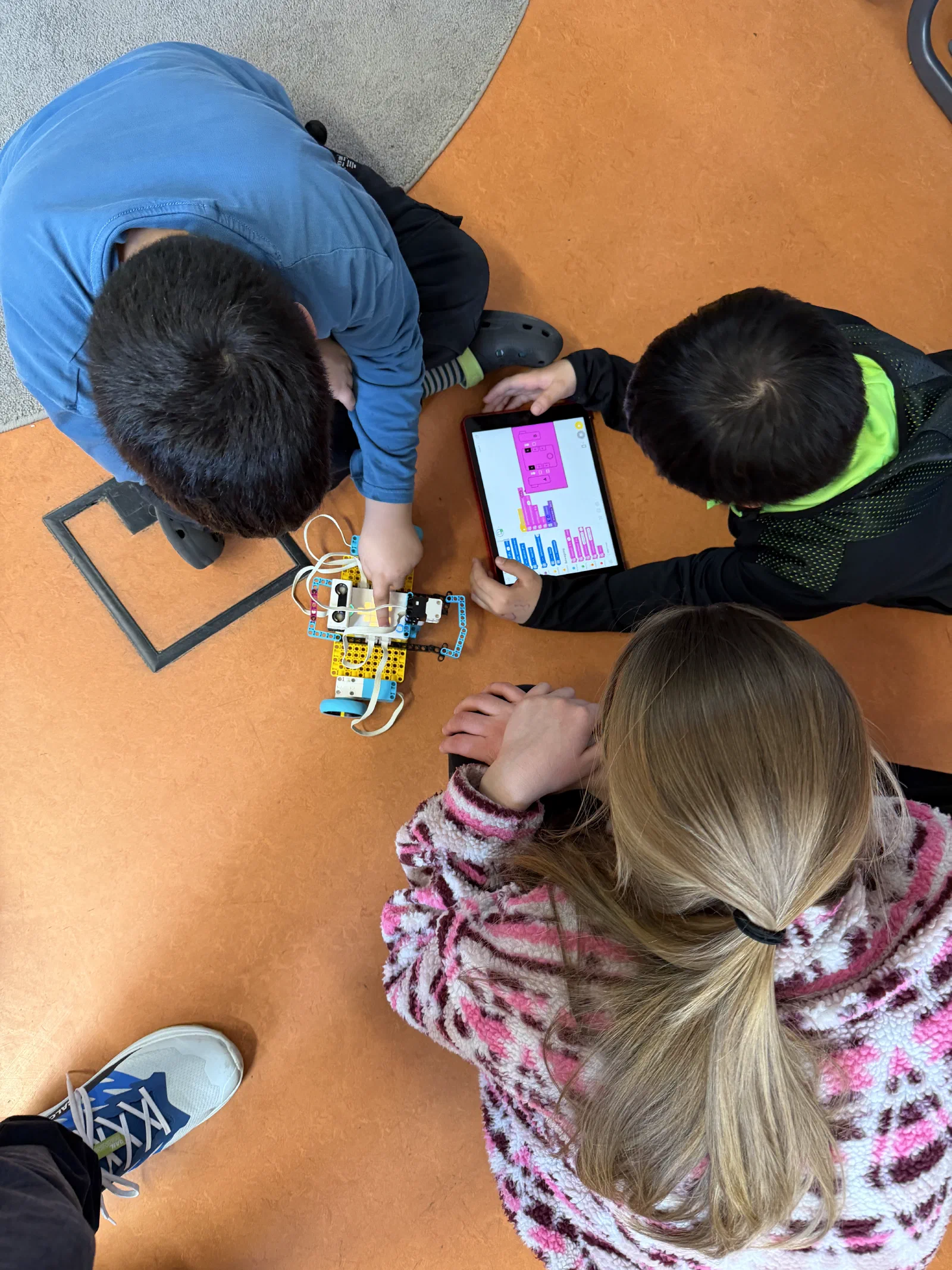 Kinder bauen LEGO Spike Roboter und programmieren per Tablet in der Technik-AG