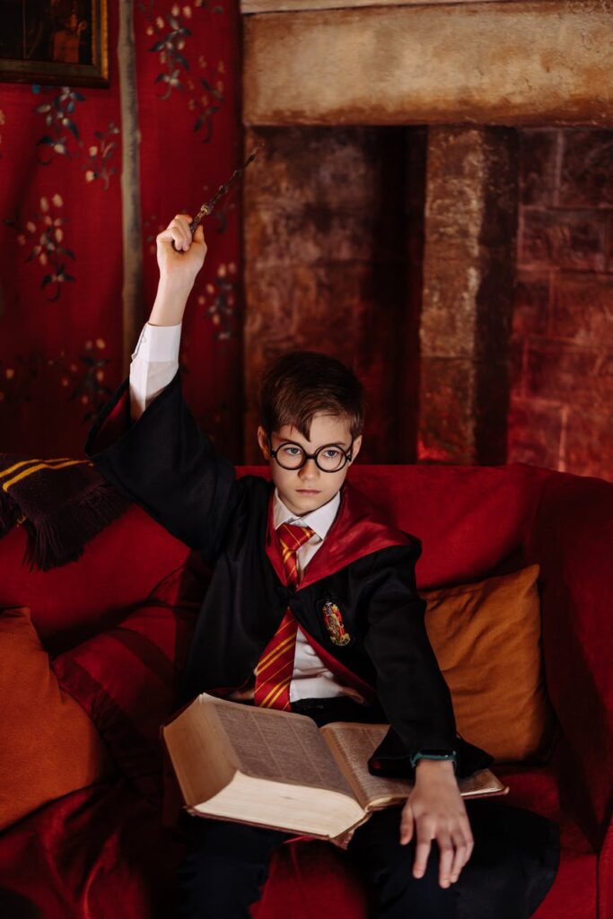 kid holding a wand and a book